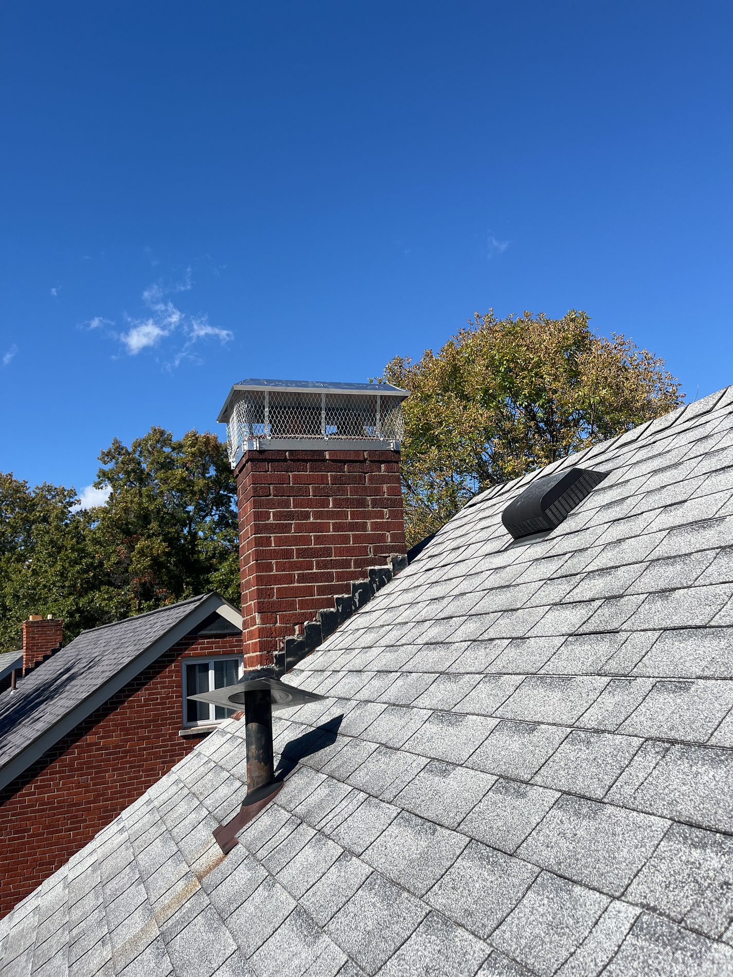 Completed chimney repair by Parker Roofing — new metal chimney cap and sealed flashing